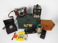 Lot to include cameras, vintage tin, boxed American Exchange wrist watch and other.