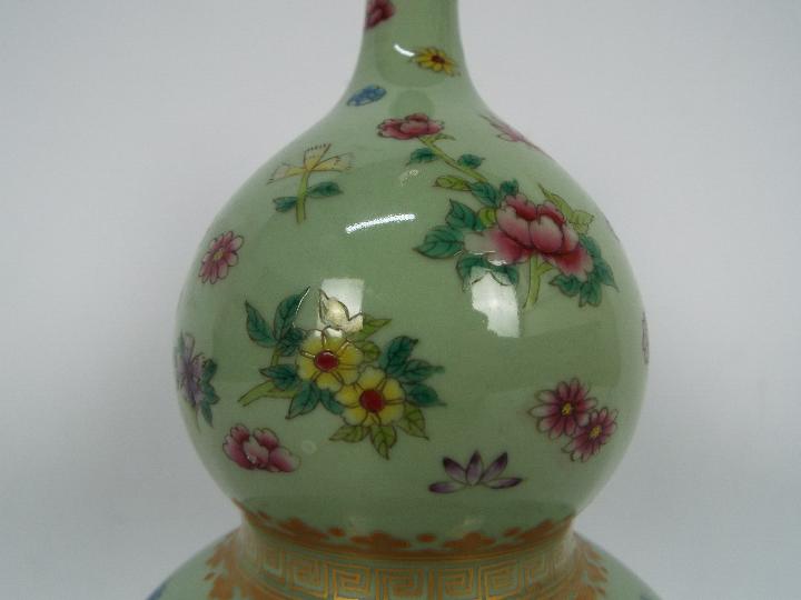 A Chinese double gourd vase decorated with flowers and butterflies against a green ground, - Image 8 of 18