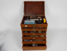 A dentists counter top or portable cabinet containing a quantity of dental tools and similar.