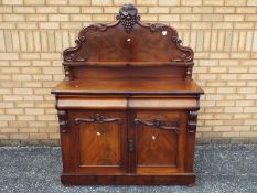 A Victorian chiffonier with carved decoration, two frieze drawers over a twin door cupboard,