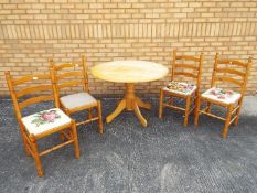 A circular topped pine kitchen table and four chairs, table approximately 74 cm x 106 cm.
