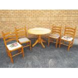 A circular topped pine kitchen table and four chairs, table approximately 74 cm x 106 cm.