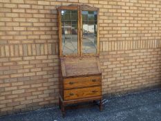 An oak bureau bookcase with astragal gla