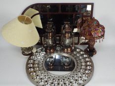 A collection of lamps including a Moroccan style table lamp and two wall mirrors.