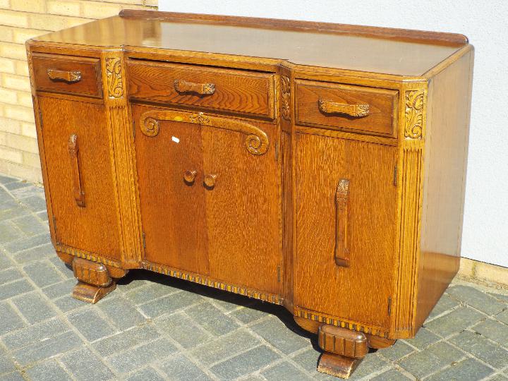 A sideboard with carved decoration measuring approximately 89 cm x 136 cm x 52 cm. - Image 2 of 3