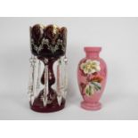 A ruby glass lustre with hand painted floral decoration and clear glass drops and a glass vase with
