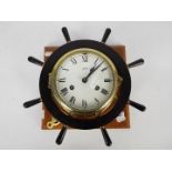 A Schatz brass bulkhead clock with ship's wheel surround.