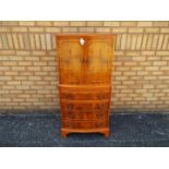 A tallboy cupboard over chest with twin door upper section over four drawers,
