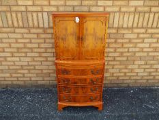 A tallboy cupboard over chest with twin door upper section over four drawers,