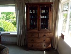 A mahogany twin-door display cabinet with glass plate shelves within,