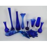 A collection of items of blue glass to include vases, dolphin model, bowls and similar.