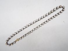 A yellow and white metal graduated crystal set necklace, approximately 40 cm (l),