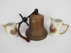 A large cast brass and iron bell, approximately 21 cm (h) and two decorative lustre jugs.