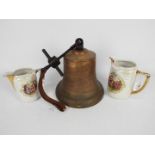 A large cast brass and iron bell, approximately 21 cm (h) and two decorative lustre jugs.