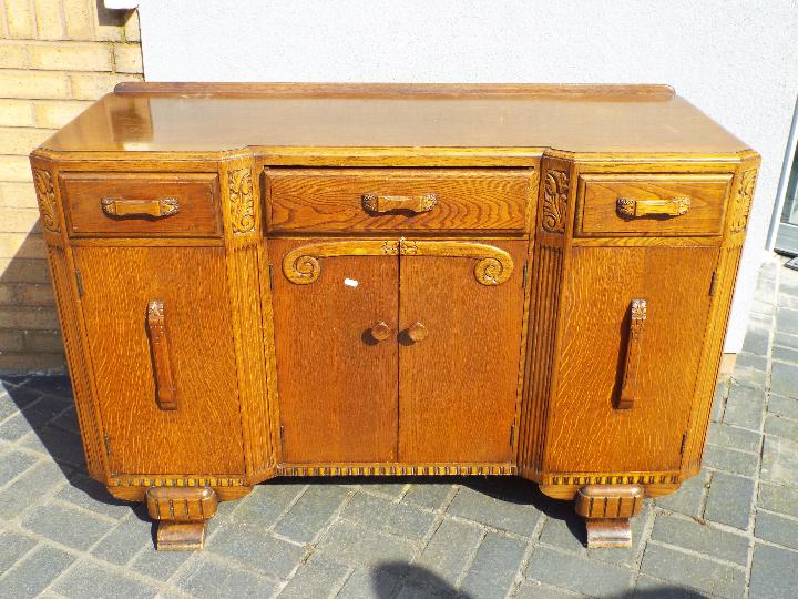 A sideboard with carved decoration measuring approximately 89 cm x 136 cm x 52 cm.