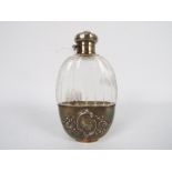 An early 20th century American glass and white metal hip flask with bayonet fitting screw top and