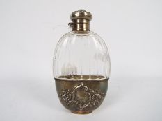 An early 20th century American glass and white metal hip flask with bayonet fitting screw top and