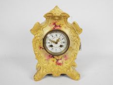 A ceramic cased mantel clock with floral decoration, approximately 30 cm (h).