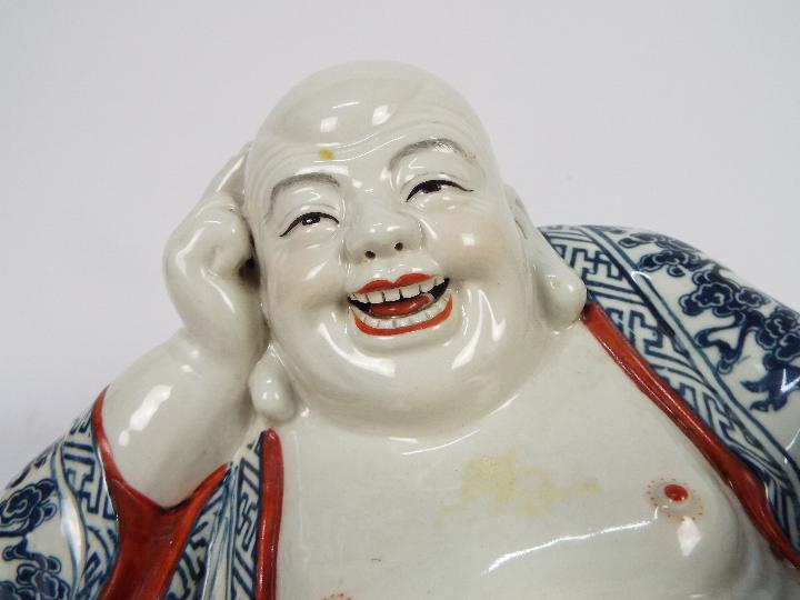 A Chinese ceramic model depicting Budai in reclining pose clutching a string of gilt beads, - Image 3 of 7