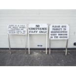 Three metal golf-course signs depicting rules.