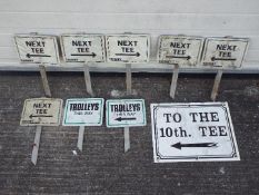 Nine directional metal golf-course signs.