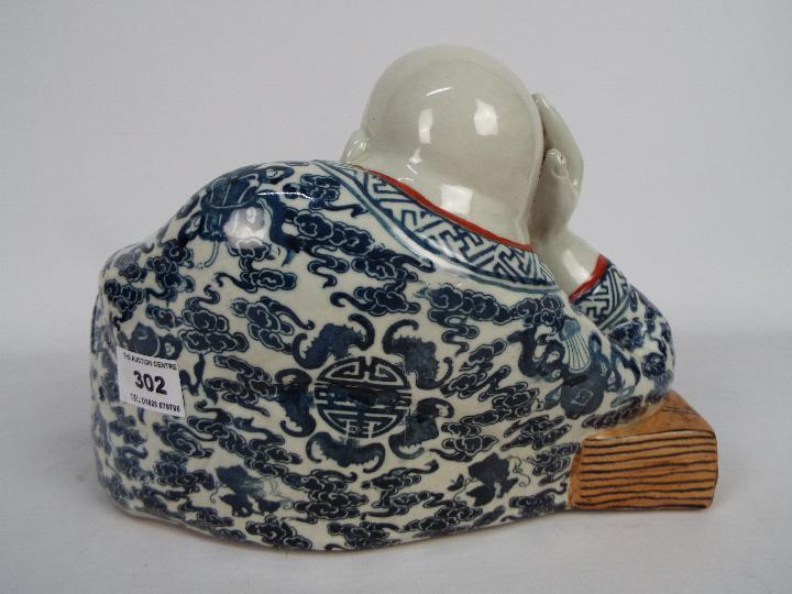 A Chinese ceramic model depicting Budai in reclining pose clutching a string of gilt beads, - Image 5 of 7