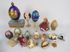 A quantity of decorative egg ornaments, some with stands.