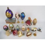 A quantity of decorative egg ornaments, some with stands.