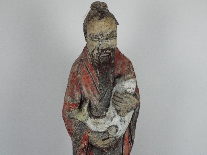 A reconstituted stone garden ornament depicting a Chinese gentleman in flowing robes holding a fish, - Image 2 of 3