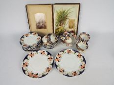 An antique photograph album and a collection of tea wares.