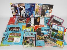 A collection of football matchday programmes, predominantly Manchester City,