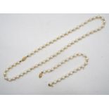 A yellow metal and pearl necklace and bracelet set, the clasp of each stamped 585 for 14ct,