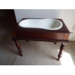 A Victorian mahogany baby bath with original ceramic pot,