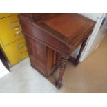 A Victorian davenport with cupboard to the side enclosing four drawers, brass castors,