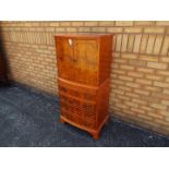 A tallboy with twin door upper section over four drawers,