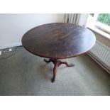 A 19th century oak round tilt-top table on tripod support,