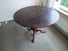 A 19th century oak round tilt-top table on tripod support,