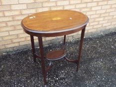 An oval topped occasional table with inlaid decoration, approximately 74 cm x 77 cm x 56 cm.