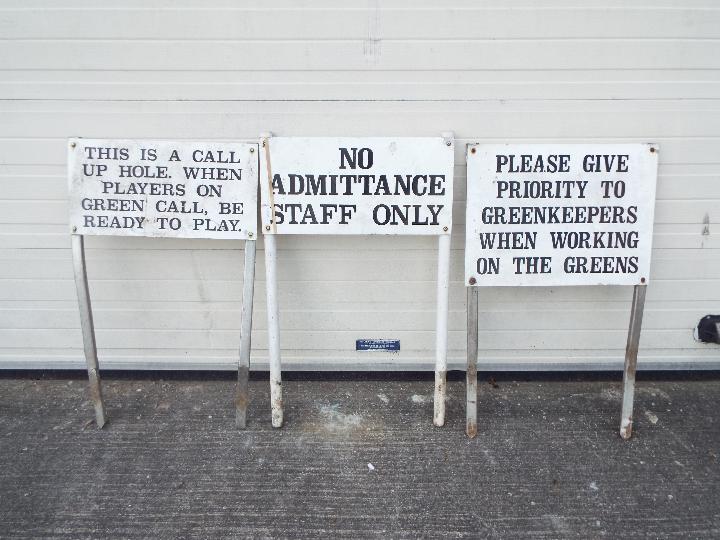 Three metal golf-course signs depicting