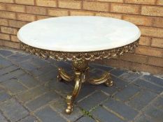A circular topped onyx and brass coffee table, approximately 45 cm x 70 cm.