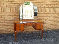 A kidney form, kneehole dressing table with triptych mirror, approximately 152 cm x 124 cm x 52 cm.
