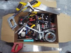 A box of various hand tools, saws, drill, screwdrivers, wrenches and similar.