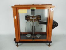 An L Oertling precision balance, model 62FM, in glazed mahogany case,