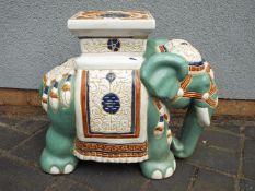 A Chinese style ceramic garden seat in the form of a caparisoned elephant, approximately 43 cm (h).