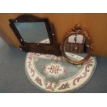 An oval framed wall mirror, one further mirror and a demi lune rug.