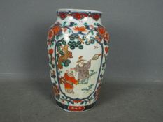 A large Chinese vase decorated with two panels of figures with foliate and floral scrolls between,