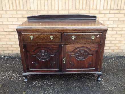 A sideboard with carved decoration measuring approximately 95 cm x 130 cm x 52 cm