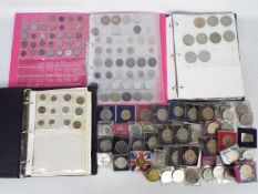 Three binders of UK and foreign coins, commemorative crowns and a quantity of loose examples.
