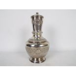 A white metal vase and cover with repousse decoration, possibly lower grade Indian silver,