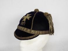 An antique university team sportsman's velvet cap with Maltese cross.